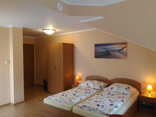 1 dormitorio pequeño con 1 cama y 2 lámparas en Posejdon, en Grzybowo