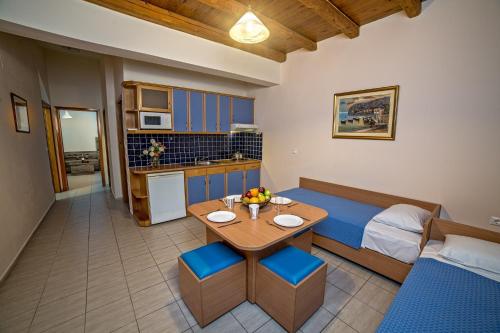 a room with a bed and a table and a kitchen at Blue Aegean Hotel & Suites in Gouves