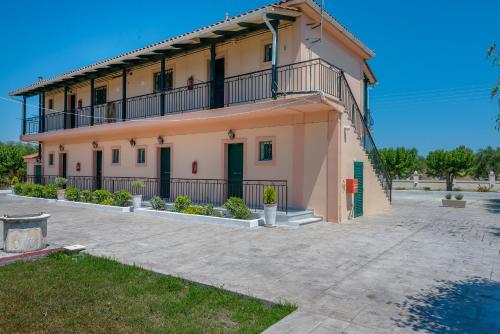 a house with a balcony on top of it at Villaggio Verde in Laganas
