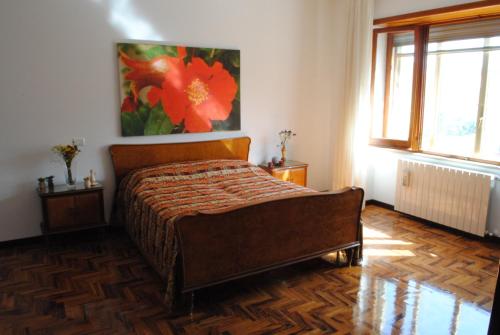 ein Schlafzimmer mit einem Bett und einem Blumenbild an der Wand in der Unterkunft Dimora Romano in Alberobello