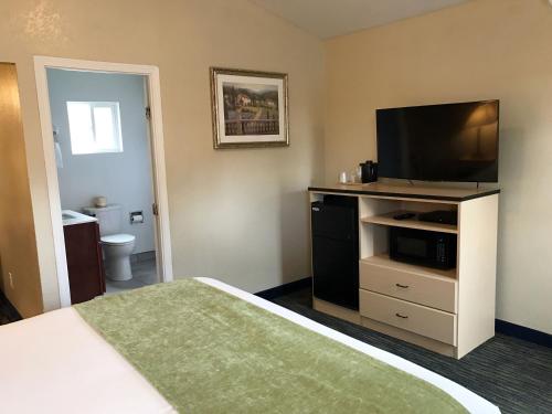 a hotel room with a bed and a flat screen tv at Napa Discovery Inn in Napa