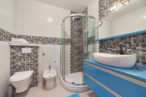 a bathroom with a sink and a toilet and a shower at Crowonder Luxury Vir- 6 New Apartments for Families with Playground for Kids in Vir