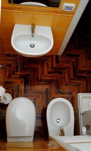 ein Badezimmer mit Waschbecken und zwei Toiletten in der Unterkunft Dimora Romano in Alberobello