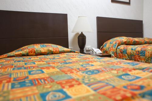 Una cama o camas en una habitación de Fiesta Versalles