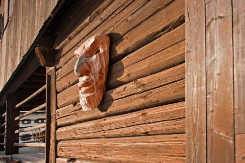 a wooden face on the side of a building at Albergo Diffuso Sauris in Sauris Di Sopra in Sauris