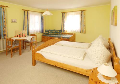 a bedroom with a bed and a table and chairs at Kinderbauernhof Salmanner in Steinbach an der Steyr
