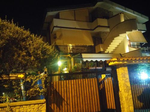 ein Gebäude mit einem Zaun in der Nacht davor in der Unterkunft Villa Melina Appartamenti in Santa Maria di Castellabate