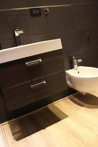 a bathroom with a white sink and a toilet at B&B La Bouganville in Alghero