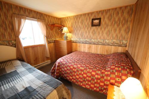 una camera d'albergo con due letti e una finestra di Blue Crest Cottages a North Rustico