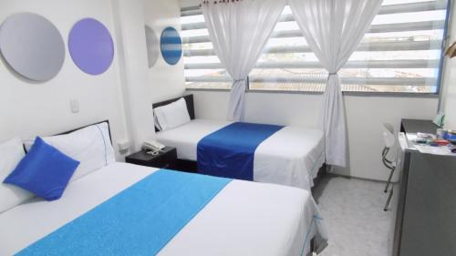 a hotel room with two beds and a window at Hotel Luna Azul in Florencia