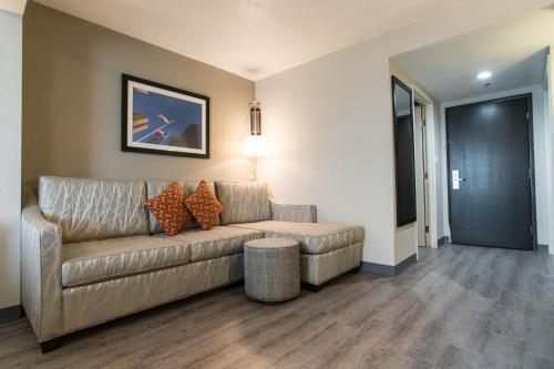 a living room with a couch and a table at Wingate by Wyndham Dallas Love Field in Dallas