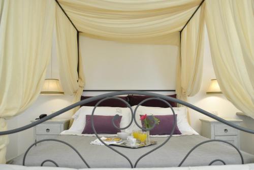a bedroom with a bed with a table with flowers on it at Masseria Panareo in Otranto