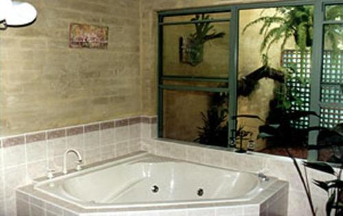 baño con bañera grande y ventana en Smoky Cape Retreat, en South West Rocks