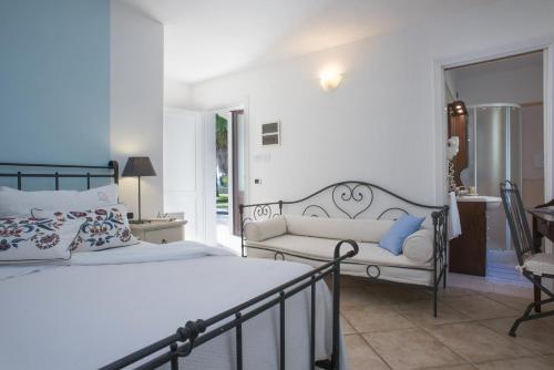 a bedroom with a bed and a couch at Masseria Panareo in Otranto