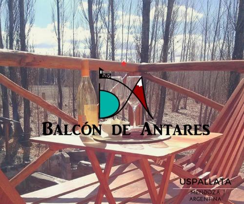 a table and a chair with a bottle on it at Balcon de Antares in Uspallata