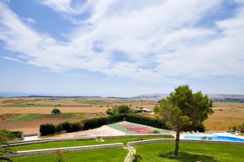 a view of a park with a swimming pool and a tree at Masseria Panareo in Otranto
