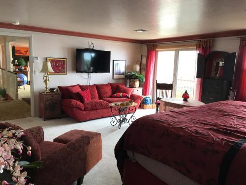 a living room with a red couch and a tv at Mermaid's Muse Bed and Breakfast in Brookings