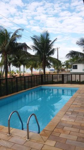a swimming pool with palm trees in the background at Apartamento na avenida da praia in Praia Grande