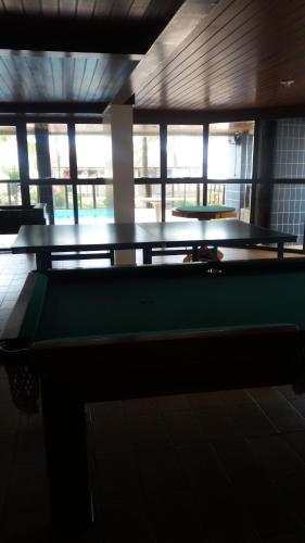 a green pool table in a room with windows at Apartamento na avenida da praia in Praia Grande