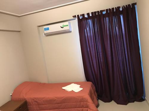 um pequeno quarto com uma cama e uma cortina em Congreso Centro em San Miguel de Tucumán