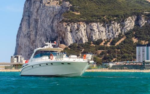 a white boat in the water near a mountain at Luxury Yacht Hotel in Gibraltar