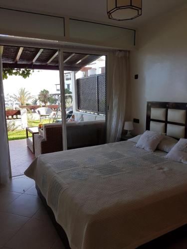 a bedroom with a large bed and a large window at Cabobeach Appartement in Cabo Negro