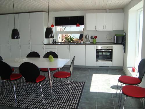 a kitchen with a table and chairs in a room at Thorupgaard Farm Holiday in Stenum