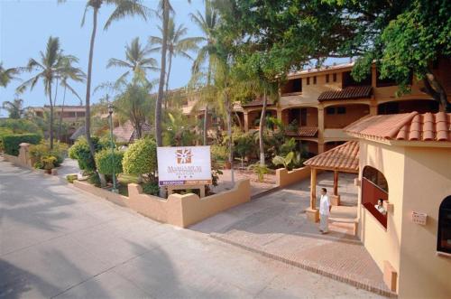 a person walking down a street in front of a building at Hotel Margaritas in Mazatlán
