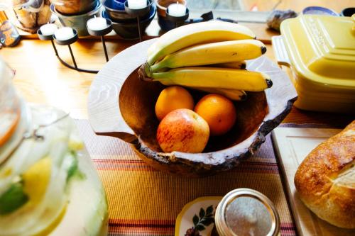 un cesto di frutta con banane e arance su un tavolo di Skeena River House Bed & Breakfast a Terrace