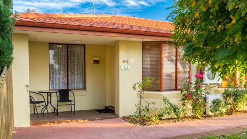 a small house with a table and chairs on the porch at Australind Tourist Park in Australind