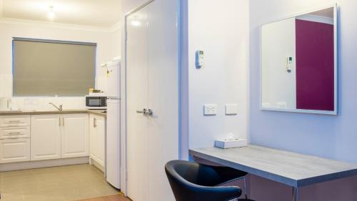 a kitchen with a desk and a chair in a room at Australind Tourist Park in Australind