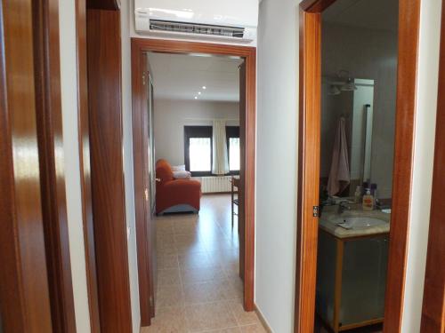 a hallway with a living room with a red chair at Merola in LʼAmetlla de Merola