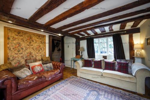 a living room with leather couches and a rug at The Buttery in Maidstone