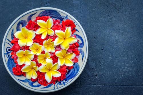 a plate with yellow flowers on a table at Kubu GWK Villa in Jimbaran