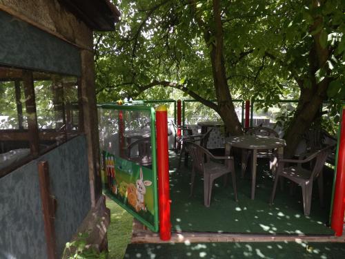 a playground with a table and chairs under a tree at Penzion Signum Laudis in Velké Hamry