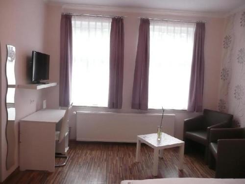 a living room with two windows and a couch and a table at H5 Hotel Bremen in Bremen