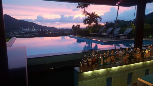 a bar with bottles on the side of a swimming pool at Baan Chom View Kamala - SHA Plus in Kamala Beach