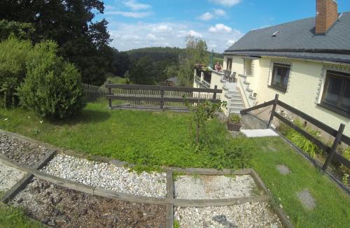 a house with a fence next to a yard at Berghof in Zeulenroda