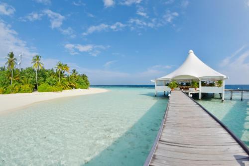 a bridge over the water with a gazebo on a beach at Safari Island in Mushimasgali