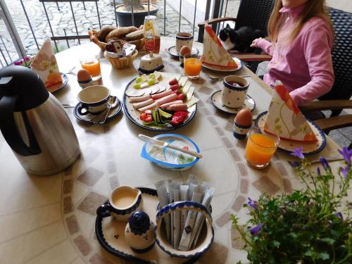 a woman sitting at a table with food and orange juice at Pension Spreeeck in Habrachćicy