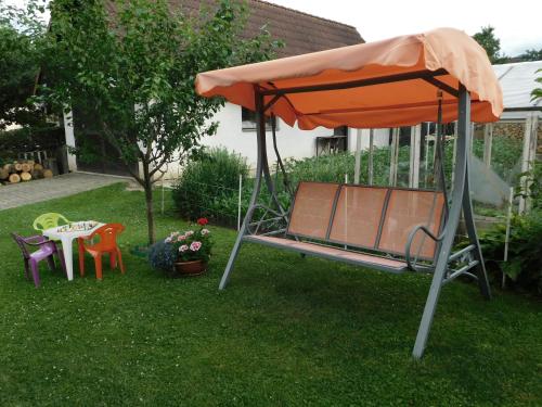 an orange umbrella in a yard with a table and chairs at Pod Dubom in Liptovský Mikuláš