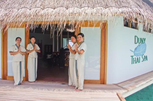 a group of people standing in front of a hut at Safari Island in Mushimasgali