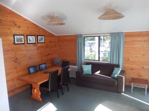 uma sala de estar com uma mesa e um sofá em Bay of Islands Holiday Park em Paihia