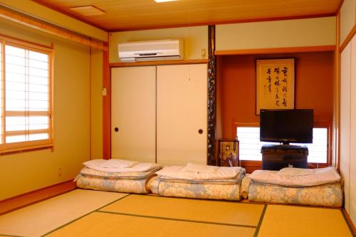 Habitación con 2 camas individuales y TV. en Mizuhokan, en Ise
