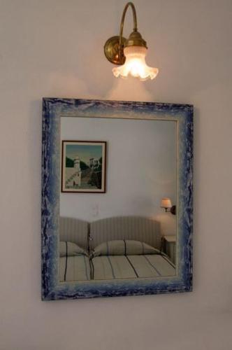 a mirror on a wall with a couch in a room at Anthousa Hotel in Apollonia
