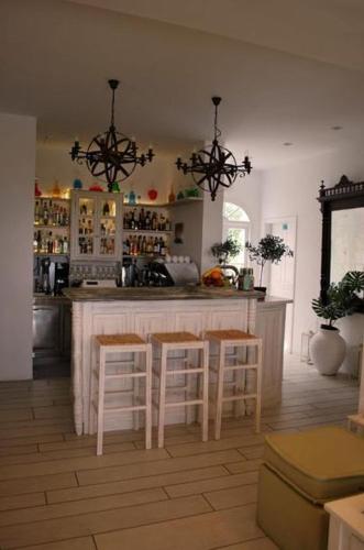 a kitchen with a bar with stools in it at Anthousa Hotel in Apollonia