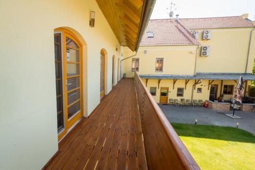a wooden deck in a house with a yard at Relax Hotel Stork in Lednice
