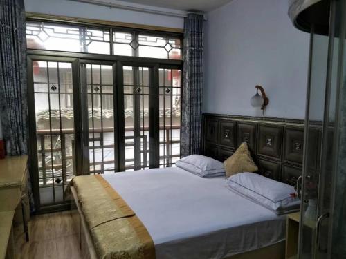 a bedroom with a bed and a large window at 166 Inn in Fenghuang County