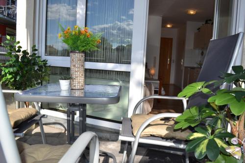 a table on a balcony with a vase of flowers at Ludwig Apartment in Ludwigsburg