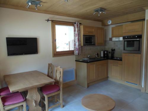 une cuisine avec une table en bois et une table et des chaises dans l'établissement Alpine Lodge 1, aux Contamines-Montjoie